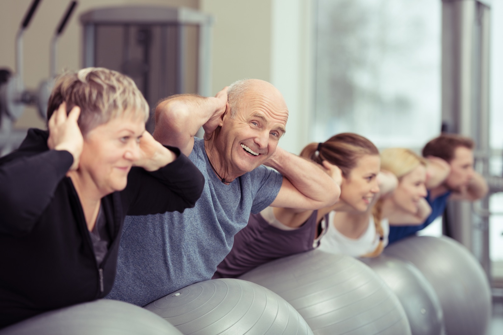 Erwachsene machen gemeinsam Rückenübungen mit Gymnastikbällen; Beispielbild, nicht dieser Kurs.